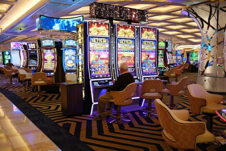 Row of slot machines glowing with bright lights on a casino floor