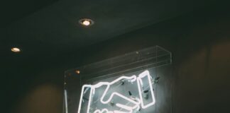 Underdog & Sportradar Announce Responsible Gaming Partnership Neon sign of a handshake