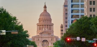 Dan Patrick’s Reelection Bid Dims Hopes for Texas Sports Betting, Casino Expansion Busy downtown street with a historic dome building in the background
