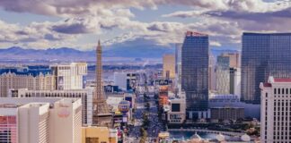 Aerial view of a busy urban skyline with tall buildings under dramatic clouds.