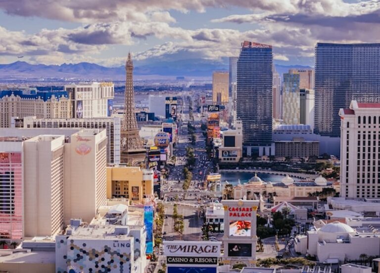 Aerial view of a busy urban skyline with tall buildings under dramatic clouds.