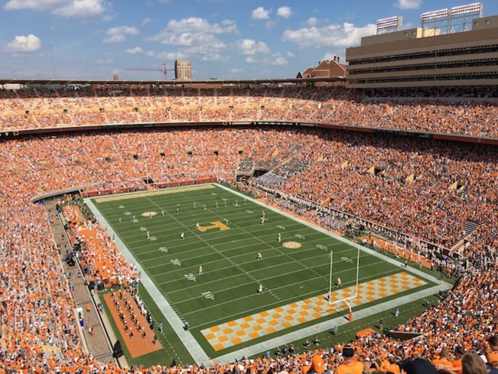 Packed college football stadium during a daytime game.