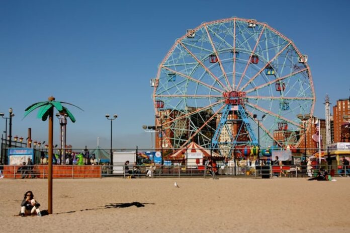 Coney Island’s Wonder Wheel on a sunny day with the beach in the foreground