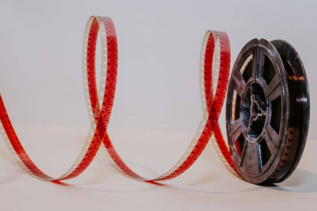 A movie reel with film unreeling next to it