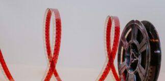 A movie reel with film unreeling next to it