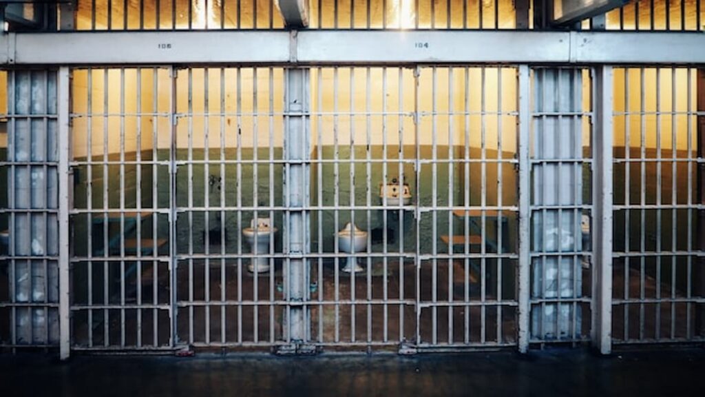 Row of prison cells with barred doors