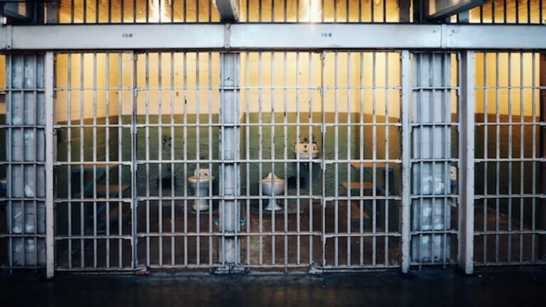 Row of prison cells with barred doors