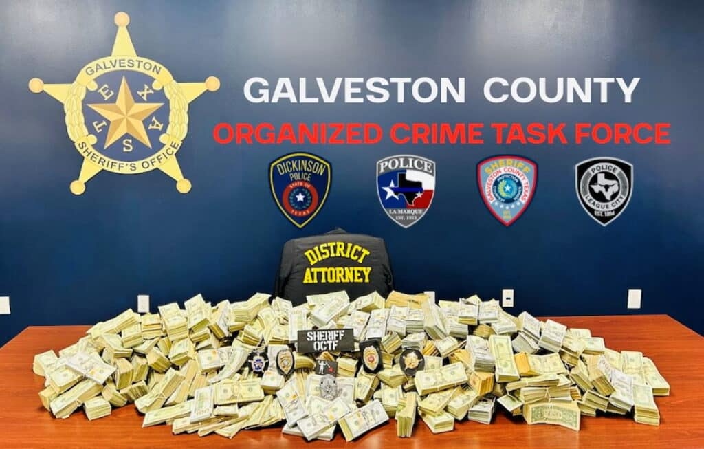 Stacks of seized cash displayed by law enforcement after a criminal investigation