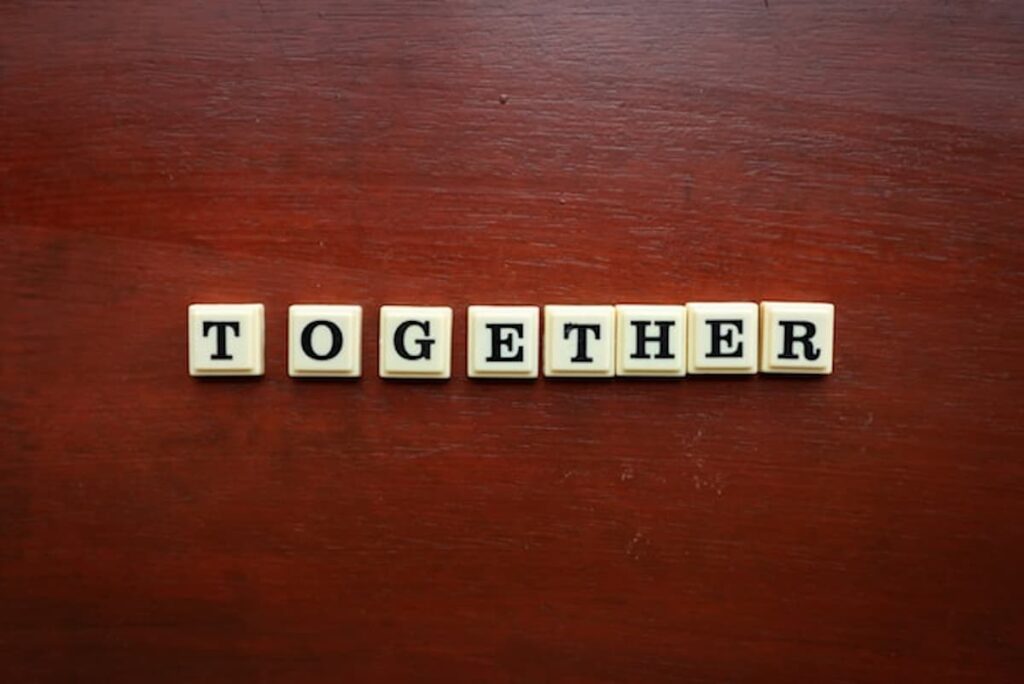 Letter tiles spelling the word “together” on a wooden surface