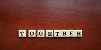 Letter tiles spelling the word “together” on a wooden surface