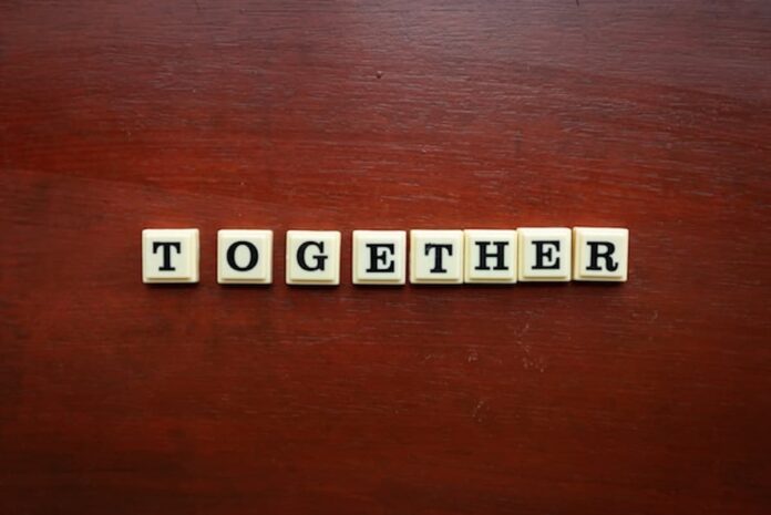 Letter tiles spelling the word “together” on a wooden surface
