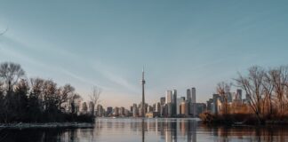 Toronto skyline with CN Tower viewed across the water at sunset.