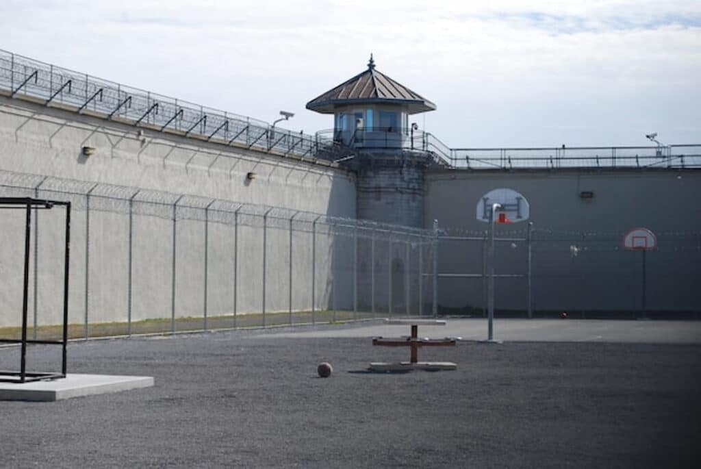 Empty prison yard with barbed wire fences.