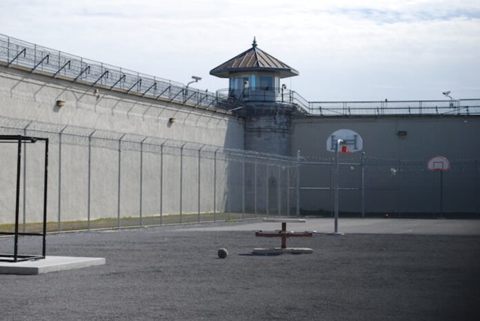 Empty prison yard with barbed wire fences.
