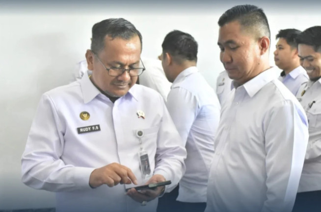 Rudy Fernando Sianturi, the Head of the South Sulawesi Directorate General of Corrections Regional Office, checks staff members’ phones.