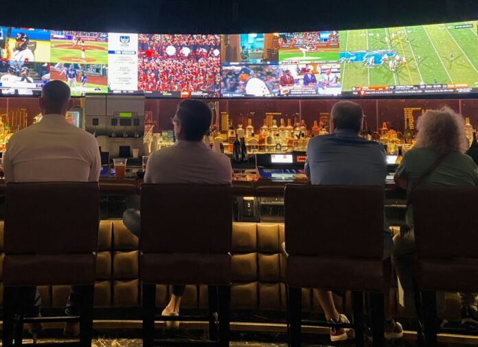 People sitting at a bar watching sports