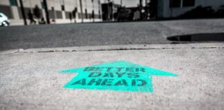 Caesars Says Vegas Slump Over, Keeps Eyes on 20% Digital Growth Arrow painted on pavement reading “Better Days Ahead.”