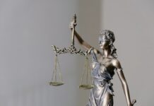 Traders File Class Action Lawsuit Against Kalshi Over Khamenei Market ‘Death Carveout’ Bronze statue of Lady Justice holding scales of law