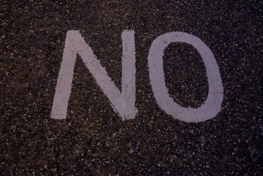 White “NO” painted on asphalt, symbolizing opposition or rejection