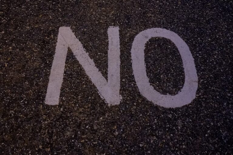 White “NO” painted on asphalt, symbolizing opposition or rejection