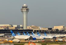 Chicago O’Hare International Airport control tower and United Airlines jets on the tarmac.