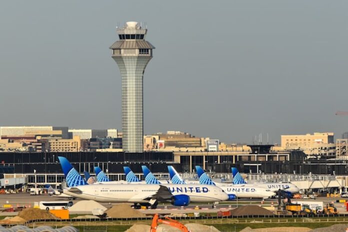 Chicago O’Hare International Airport control tower and United Airlines jets on the tarmac.