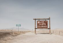 Welcome to Colorful Colorado road sign in desert landscape.