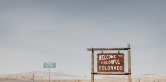Welcome to Colorful Colorado road sign in desert landscape.