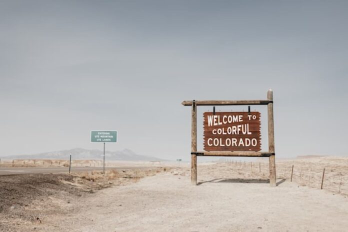 Welcome to Colorful Colorado road sign in desert landscape.