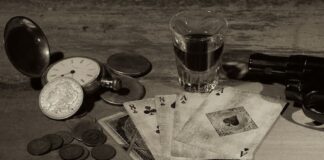 Early Plea Talks Begin in Mob-Linked Gambling Case, Prosecutors Say Vintage playing cards, poker chips, and coins on a wooden table symbolizing illegal gambling and betting culture.