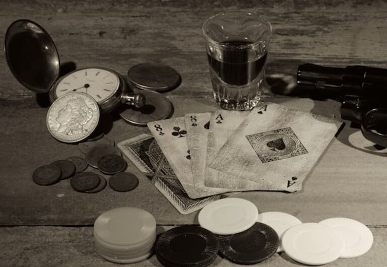 Vintage playing cards, poker chips, and coins on a wooden table symbolizing illegal gambling and betting culture.