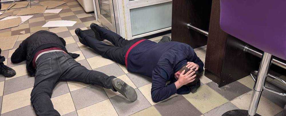 Law enforcement officers order suspects to the floor in a raid on a suspected illegal casino operating in a Siberian hospital.