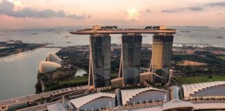 Las Vegas Sands Q3 Results Show Strong Asia Rebound, US Digital Retreat Aerial view of a landmark waterfront resort complex with high-rise towers and unique architectural design.