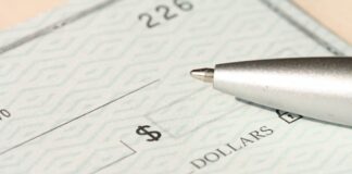 Kraken Acquires CFTC-Regulated Small Exchange in $100M Bid for US Derivatives Expansion A person preparing to write a check on a blank form