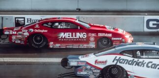 Two race cars driving side by side on a racing track.