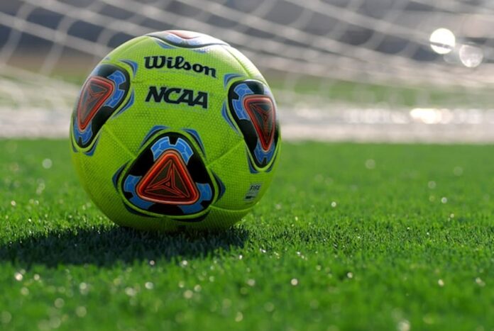 NCAA Formally Approves Pro-Sports Betting Rule for Student-Athletes & Staff Across All Divisions Bright yellow soccer ball on green turf in front of goal