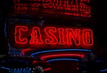 Red neon casino sign glowing against dark background.