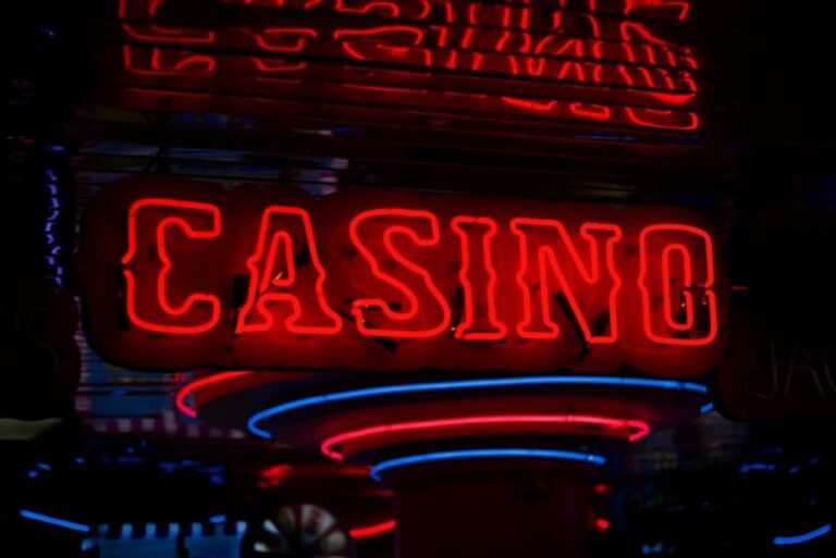 Red neon casino sign glowing against dark background.