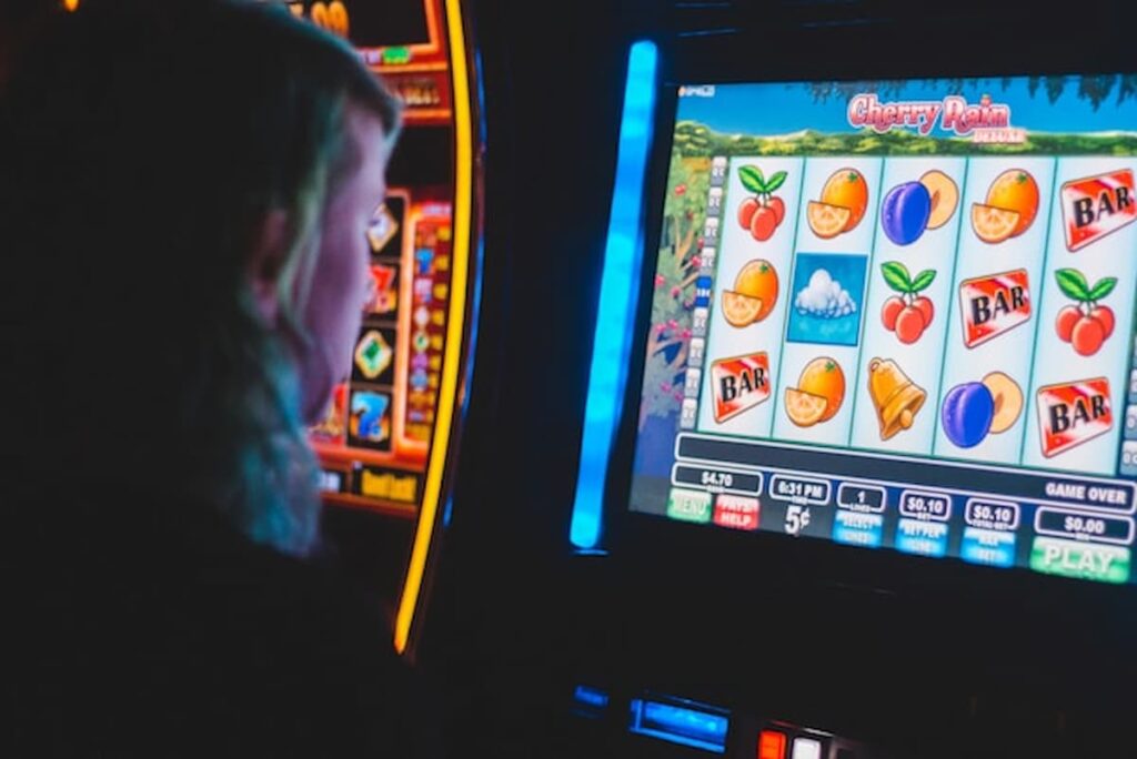 Person playing a colorful slot-style machine.