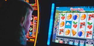 Person playing a colorful slot-style machine.