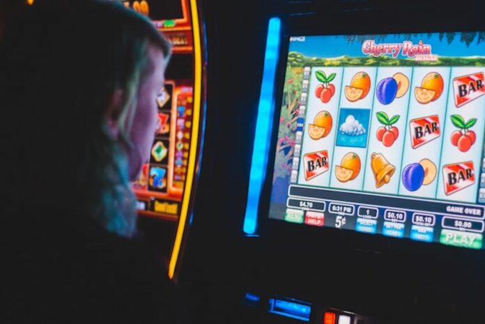 Person playing a colorful slot-style machine.