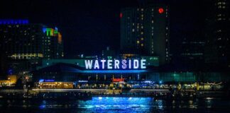 Lease Approval Pushes Norfolk Casino Forward as Virginia’s Gaming Expansion Builds Neon sign reflecting over city waterfront at night