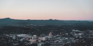 Aerial view of downtown Roanoke, Virginia, surrounded by the Blue Ridge Mountains at dusk.
