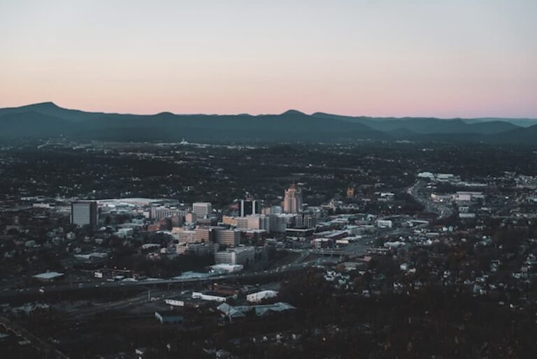 Aerial view of downtown Roanoke, Virginia, surrounded by the Blue Ridge Mountains at dusk.