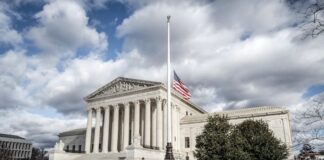 The U.S. Supreme Court building in Washington, D.C., with the American flag at half-mast