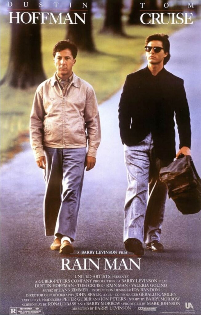 Roadside poster of Raymond Babbitt (Dustin Hoffman) walking beside his brother Charlie Babbitt (Tom Cruise) in sunglasses, with the title “RAIN MAN.”