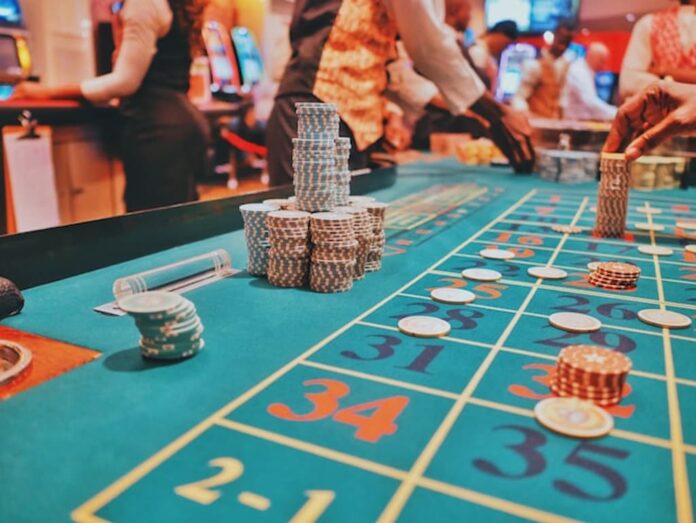 Stacks of casino chips on a roulette table inside a gaming venue.