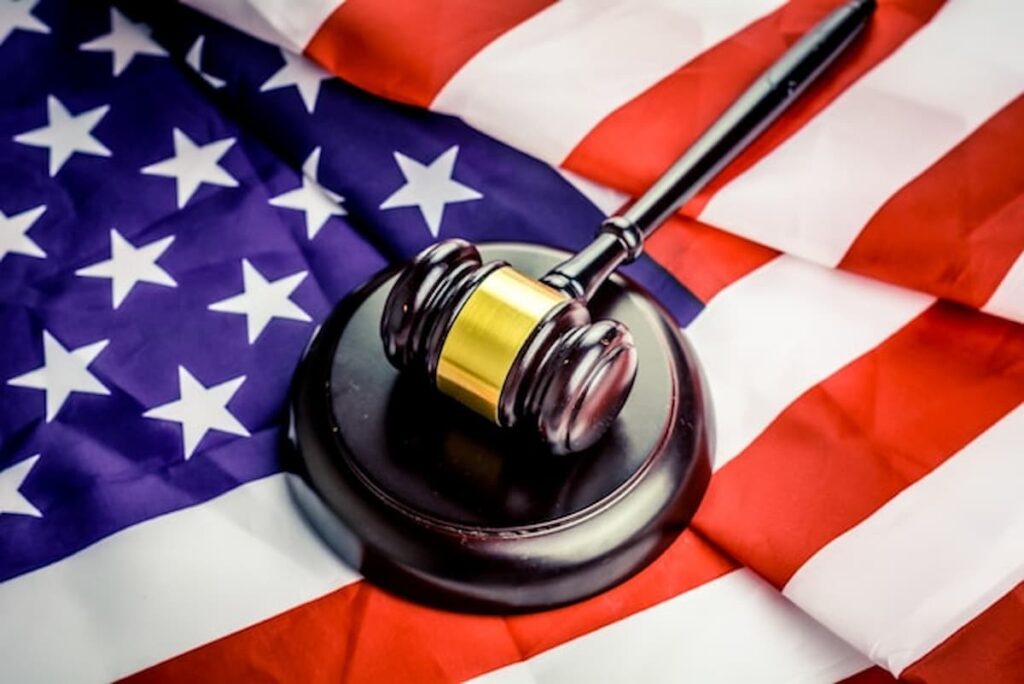 A judge’s gavel resting on an American flag.