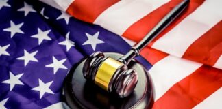 A judge’s gavel resting on an American flag.