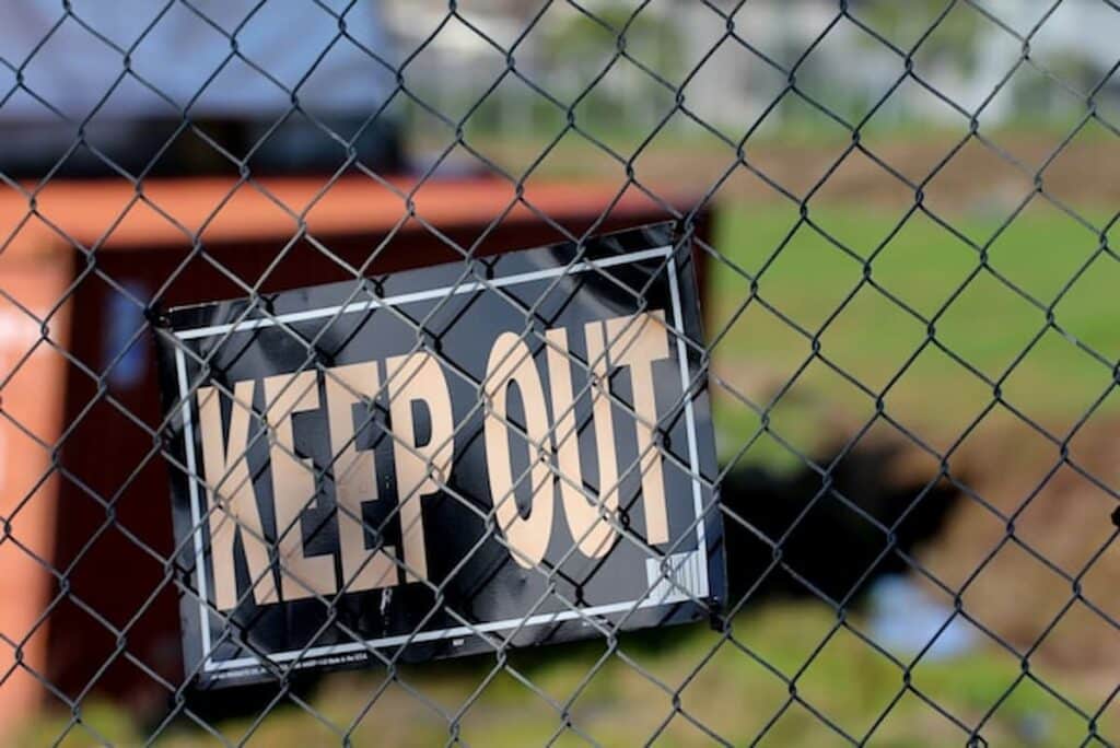 Keep Out sign hanging on a chain-link fence